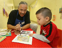 Photo of older man working with young boy